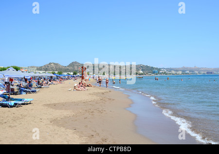 La spiaggia nella divertente e vivace località di Faliraki sulla popolare isola greca di Rodi Foto Stock