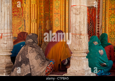 Le donne musulmane di indossare headscarfs colorati e dei sari pregare presso la Nizam-Ud Din a Santuario di Delhi, India Foto Stock