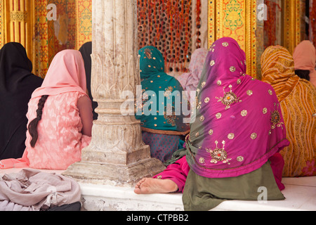 Le donne musulmane di indossare headscarfs colorati e dei sari pregare presso la Nizam-Ud Din a Santuario di Delhi, India Foto Stock