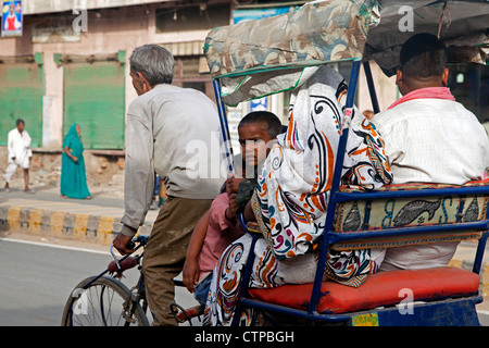 Risciò ciclo con il vecchio driver di trasportare la famiglia come il trasporto urbano in Mathura, Uttar Pradesh, India Foto Stock