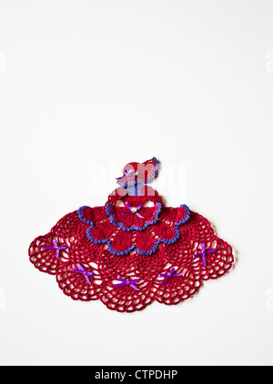 Primo piano stile vittoriano taglio di moda di un Red Hat Ladies Society Senior Woman's club, crochet doily in rosso e viola filo crochet modello ritagliato Foto Stock
