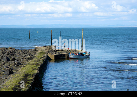 Il grazioso porto di Lynmouth, Devon, Inghilterra a bassa marea con barca per gite turistiche ormeggiata in acque più profonde. Foto Stock