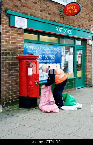 Portalettere lo svuotamento di casella di posta al di fuori del post office Foto Stock