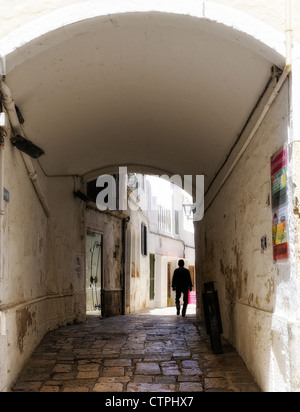 Un uomo a piedi attraverso un vicolo in Mahon Minorca spagna Foto Stock