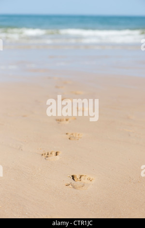 Orme su una spiaggia a piedi verso il mare. Pozzetti accanto al mare. Norfolk, Inghilterra Foto Stock