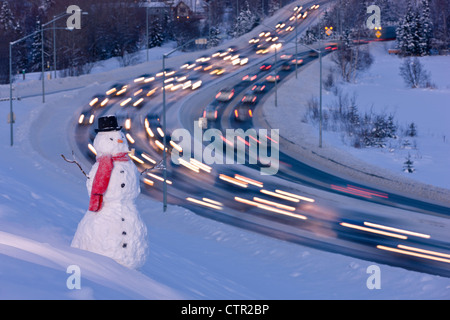 Vista del traffico vicino al centro cittadino di Anchorage con un pupazzo di neve in primo piano, centromeridionale Alaska, l'inverno. Digital Enhanced Foto Stock