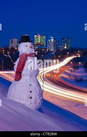 Vista del traffico e il centro cittadino di Anchorage con un pupazzo di neve in primo piano, centromeridionale Alaska, l'inverno. Migliorate digitalmente. Foto Stock