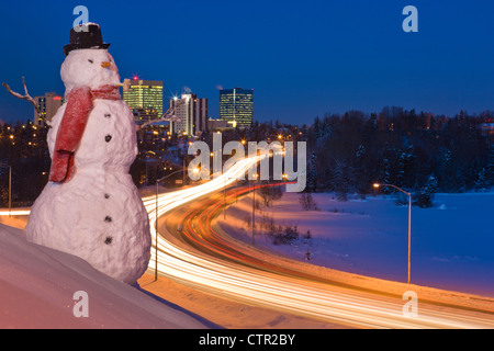 Vista del traffico e il centro cittadino di Anchorage con un pupazzo di neve in primo piano, centromeridionale Alaska, l'inverno. Migliorate digitalmente. Foto Stock