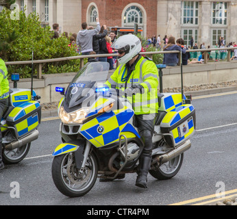 La polizia motociclista a cavallo della sua moto stazionario in carreggiata, Dorset, England, Regno Unito Foto Stock