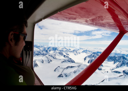 Scalatore guardando fuori dalla finestra da un Turbo Otter al Wrangell-Saint Elias montagne, Yukon Territory, Canada, estate Foto Stock