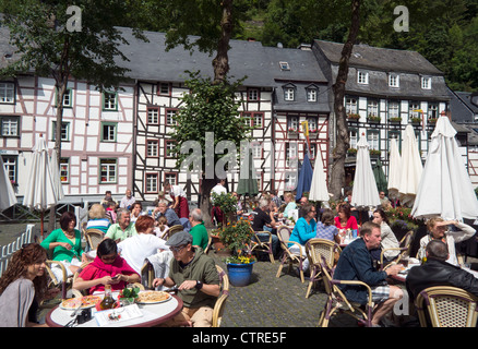 Occupato di un ristorante esterno con i turisti nel villaggio storico di Monschau nella regione Eifel di Germania Foto Stock