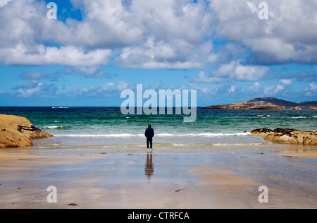 Uomo che guarda all'oceano dalla spiaggia Foto Stock