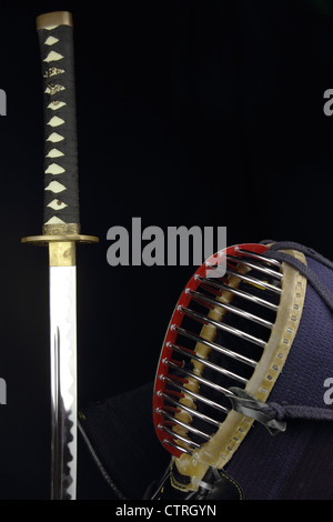 Spada katana di Kendo e casco su sfondo nero Foto Stock