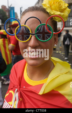 Indossare anello olimpico occhiali, una signora ventola sports tours Londra centrale durante una pausa la visione di eventi durante le Olimpiadi di Londra 2012. Indossando il loro paese i colori nazionali Gli Amici godono di una tregua dalle piogge estive a camminare attraverso la capitale le strade. Foto Stock