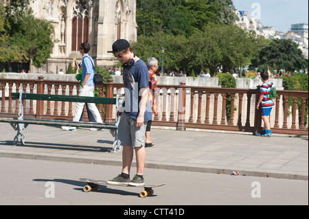 Parigi, Francia - Young Teen lo skateboard su un ponte sul fiume Senna. Foto Stock