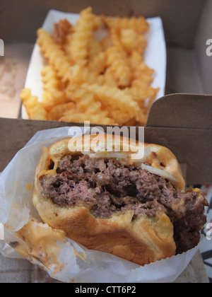 Semi-mangiato cheeseburger e patatine fritte, Shake Shack, Madison Square Park, New York, Stati Uniti d'America, 16 luglio 2012, © Katharine Andriotis Foto Stock