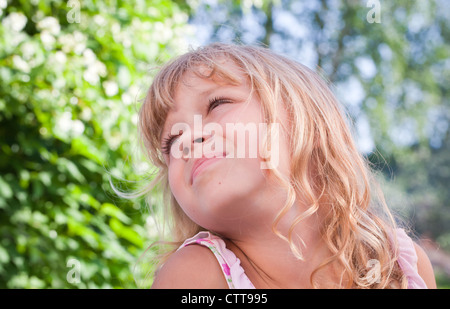 Ritratto di un sorridente leggermente piccola bionda bella ragazza Russa al di sopra della natura sfondo all'aperto Foto Stock