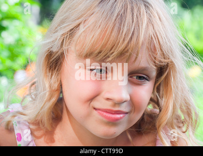 Ritratto di un sorridente leggermente piccola bionda bella ragazza Russa al di sopra della natura sfondo all'aperto Foto Stock