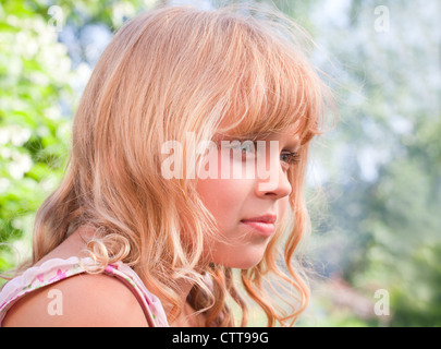 Ritratto di un sorridente leggermente piccola bionda bella ragazza Russa al di sopra della natura sfondo all'aperto Foto Stock