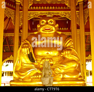 Stock Photo - sorridente Golden statua del Buddha, dio cinese di felicità, la ricchezza e la fortuna isolato su bianco Foto Stock