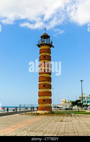 Un vecchio faro di mattoni rossi situato sulle rive del fiume Tago tra la Torre di Belem e il Monumento delle Scoperte Foto Stock