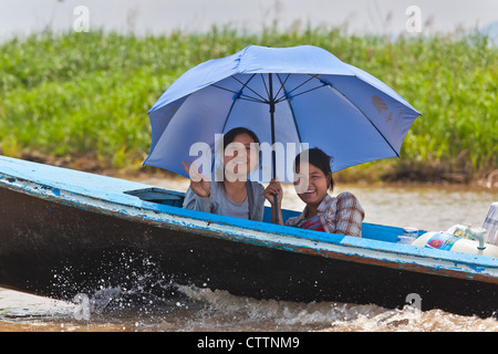Donna birmano utilizzare un ombrello come protezione contro il sole sul Lago Inle - Myanmar Foto Stock