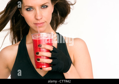 Un atleta refuels con un frullato di frutta tra esecuzioni Foto Stock