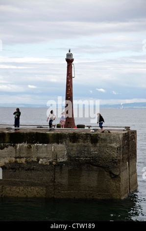 Bambini che giocano sul molo a Anstruther in East Neuk di Fife, Scozia. Foto Stock