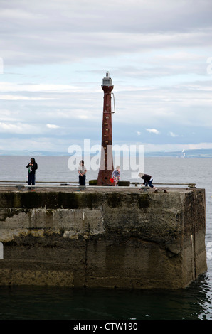 Bambini che giocano sul molo a Anstruther in East Neuk di Fife, Scozia. Foto Stock