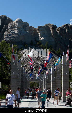 Vista di Mt. Rushmore con i visitatori a piedi lungo le bandiere degli Stati Uniti, il Monte Rushmore monumento nazionale, il Dakota del Sud, STATI UNITI D'AMERICA Foto Stock