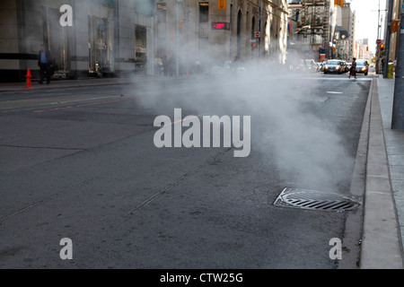 Toronto giugno 2012, il vapore proveniente da un chiusino in una città di Toronto Street al di fuori del Trump International Hotel & Tower Foto Stock