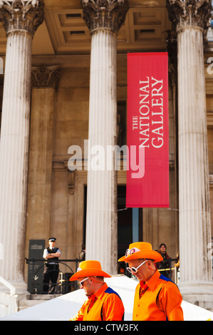 Due uomini vestiti in arancione nella parte anteriore della National Gallery in Trafalgar Square, come parte della Holland House Festival 2010. Foto Stock