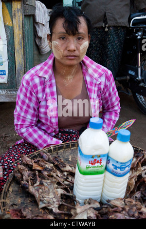 Myanmar Birmania. Donna vendita di grigliate di pipistrelli in Bagan mercato. Indossa thanaka incollare sul suo volto, un cosmetico sunscreen. Foto Stock