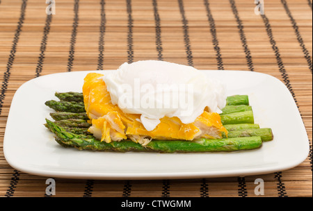 Eglefino affumicato, asparagi e un uovo in camicia la cena disposti su una piastra di cina Foto Stock