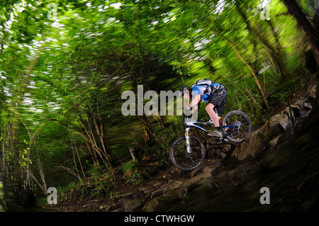 Un mountain biker cavalca un sentiero roccioso nei pressi del villaggio di Cheddar in Somerset sul bordo meridionale di Mendip Hills. Foto Stock