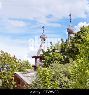 Chiesa di legno in giardino verde sotto il cielo blu Foto Stock