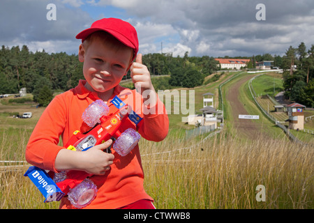 Ragazzo con il giocattolo auto racing di fronte racetrack, Teterow, Mecklenburg-Switzerland, Meclemburgo-Pomerania Occidentale, Germania Foto Stock