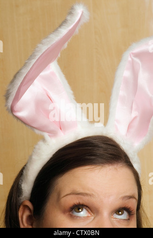 Una donna che indossa bunny orecchie. Foto Stock