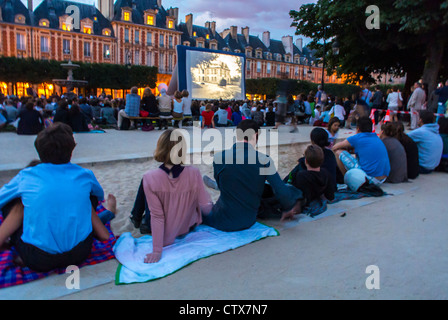 Parigi, Francia, Audience from Behind at Open Air, Outdoor Cinema Show, Forum des Images, in the Square, Place des Vosges, nel Marais, esterno, evento gratuito, andare al cinema, persone al cinema all'aperto, un film serale a Parigi Foto Stock