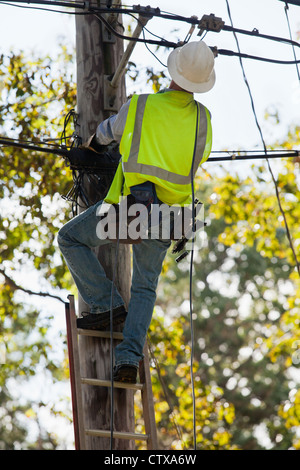 Lineman ottenere pronto per l'installazione di cavo di collegamento ad un home Foto Stock