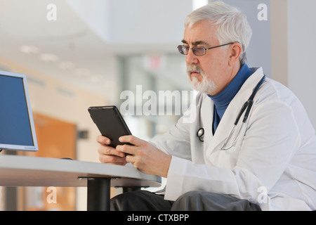 Medico guardando al suo tablet Foto Stock