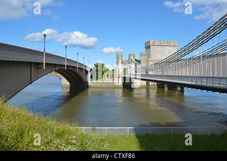 Moderna strada ponte vecchio di sinistra Telford road Suspension Bridge & Stephenson ferro battuto ferroviaria tubolare ponte che attraversa il fiume Conwy Foto Stock