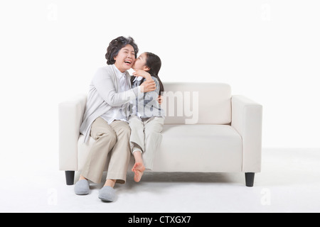 Un nipote baciare sulla nonna guancia Foto Stock