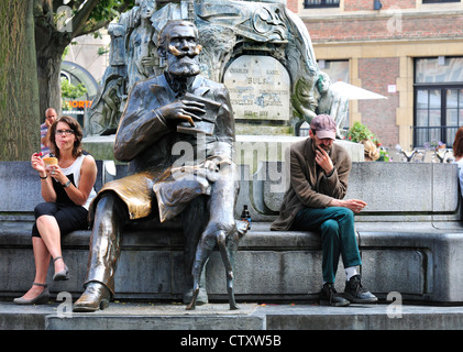 Bruxelles, Belgio. Memoriale di Charles / Karel Buls. La donna a mangiare il gelato, uomo seduto pensando Foto Stock