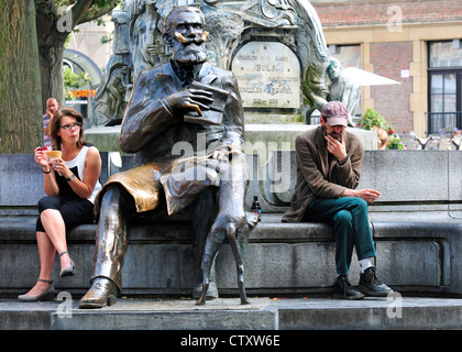 Bruxelles, Belgio. Memoriale di Charles / Karel Buls. La donna a mangiare il gelato, uomo seduto pensando Foto Stock