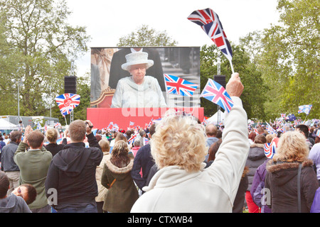 Spettatori guardare il grande schermo durante il royal carrello processione attraverso il centro di Londra come parte del diamante celebra il Giubileo Foto Stock