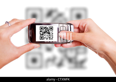 Le mani umane tenendo smart phone e scansione del codice QR Foto Stock