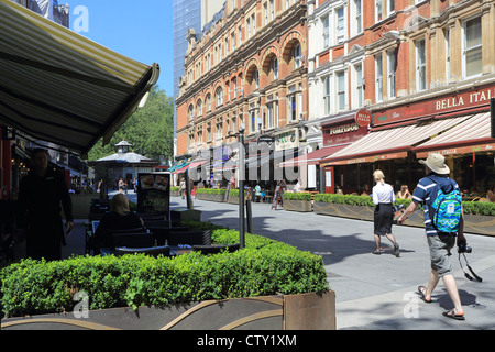 I turisti a piedi ristoranti passato su Irving Street verso Leicester Square, nel West End, in un giorno d'estate, a Londra, Regno Unito Foto Stock