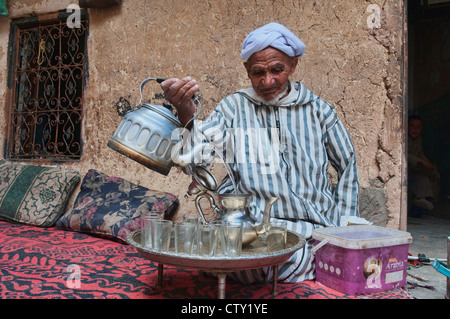 Tradizionali Berbere nonno versando il tè nel sud montagne Atlas, Marocco Foto Stock