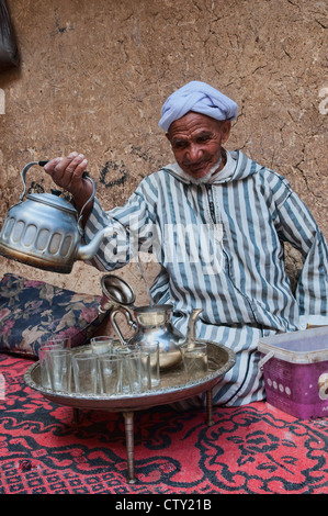 Tradizionali Berbere nonno versando il tè nel sud montagne Atlas, Marocco Foto Stock